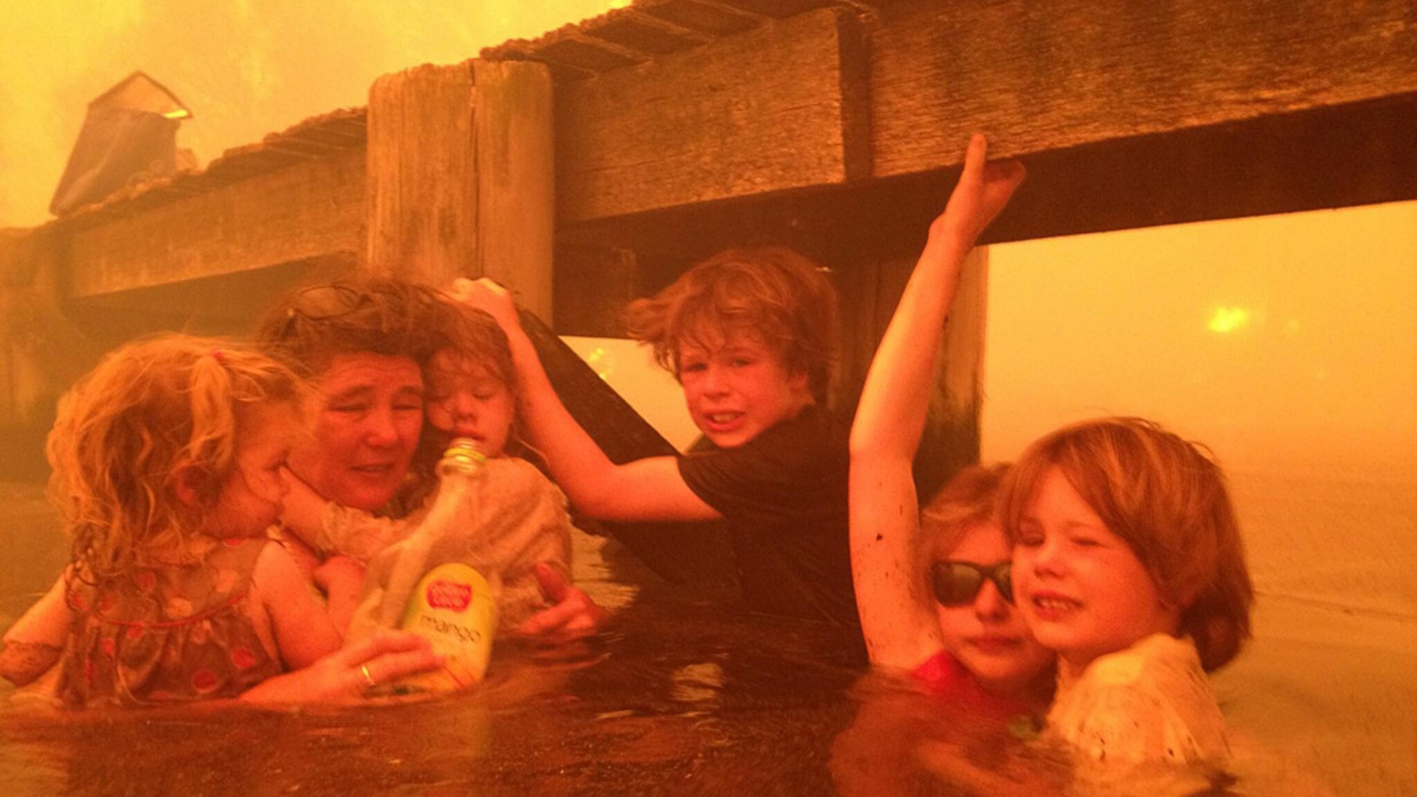Le foto drammatiche di un’intera famiglia costretta a rifugiarsi in acqua, sotto un molo, per salvarsi dagli incendi che stanno devastando l’Australia. Cinque bambini e i loro nonni sono rimasti abbracciati per ore al freddo mentre tutto bruciava.