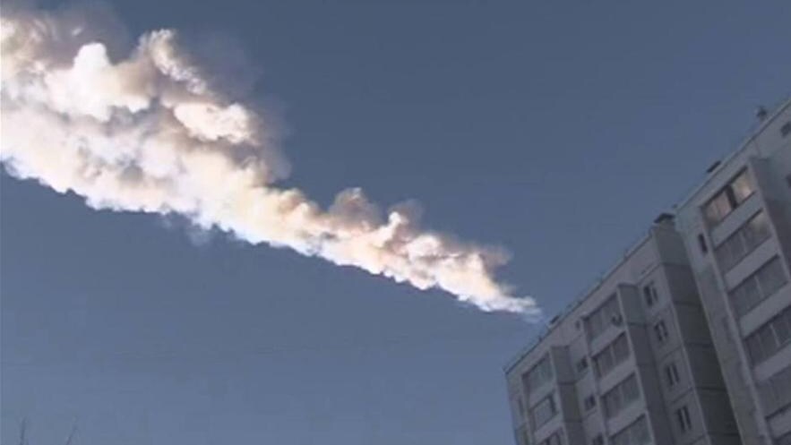 Still image from video shows the trail of a falling object above a residential apartment block in the Urals city of Chelyabinsk
