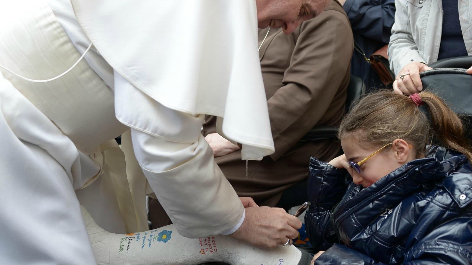 Ieri, in occasione della seconda udienza generale, Papa Bergoglio ha compiuto un giro tra i fedeli giunti a Roma, salutando e baciando i più piccoli. E nei confronti di una bambina con la gamba ingessata ha avuto un’attenzione particolare…