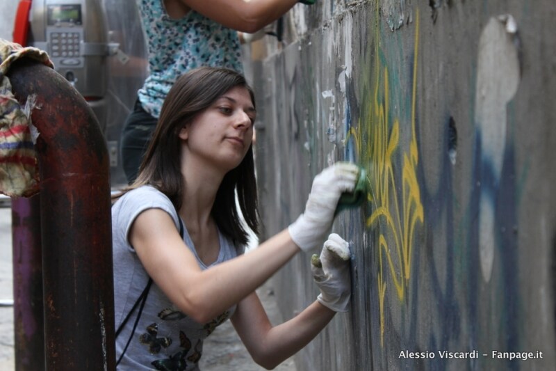 Una ragazza di CleaNap pulisce dai murales