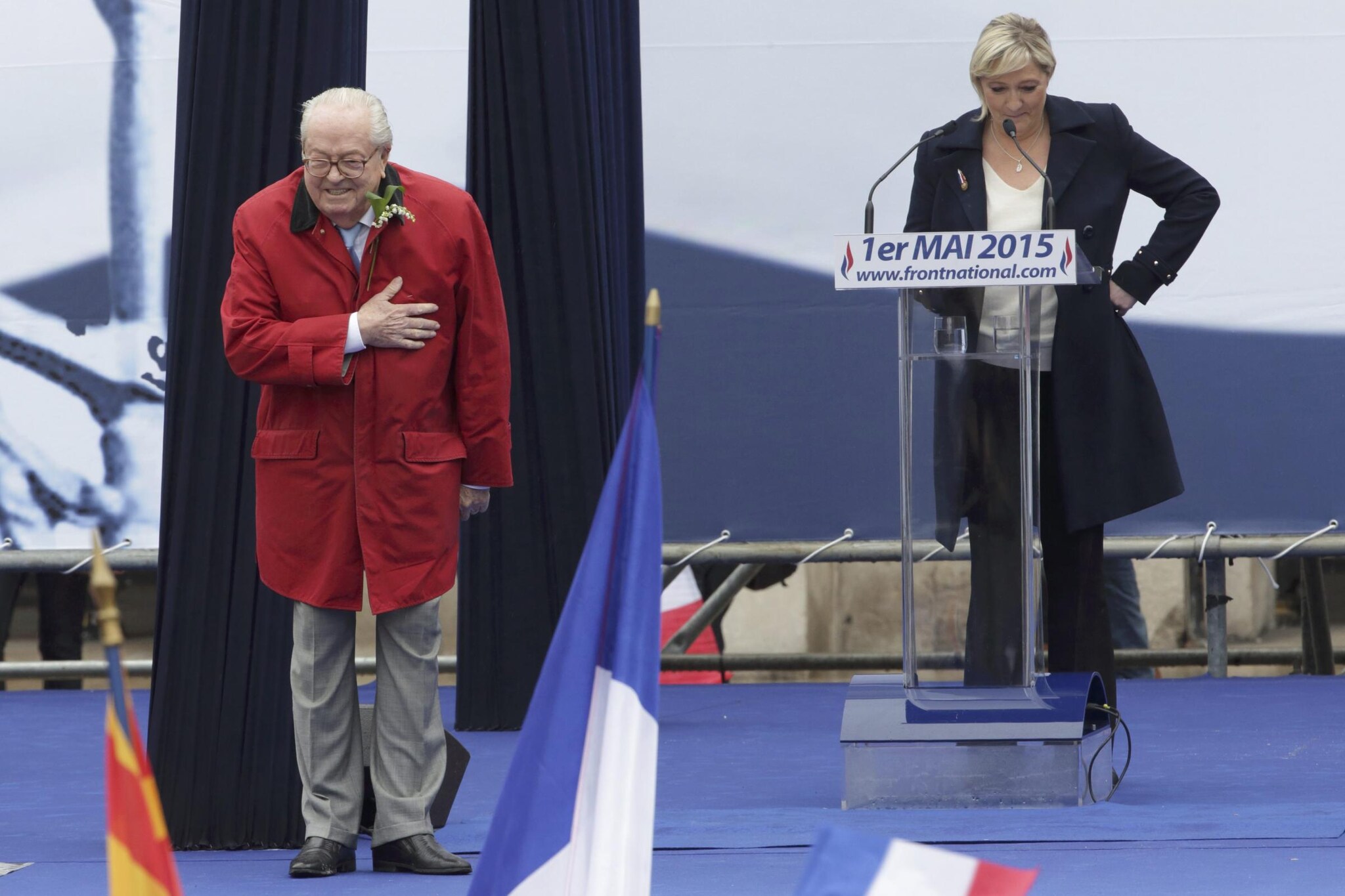 France’s far–right National Front political party leader Marine Le Pen (R) watches as her father Jean–Marie Le Pen, party founder and honorary president, reacts on the podium at their traditional May Day tribute to Joan of Arc in Paris, France, May 1, 2015. REUTERS/Philippe Wojazer TPX IMAGES OF THE DAY