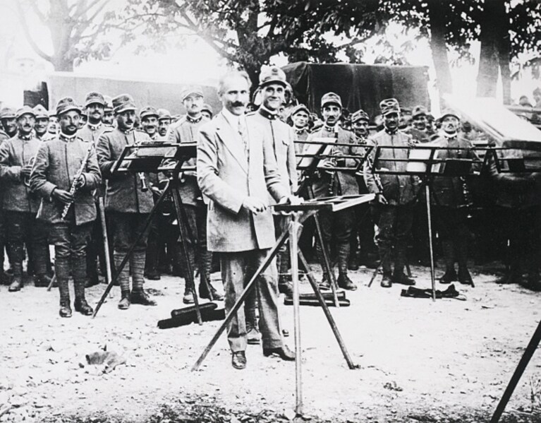 Arturo Toscanini dirige un'orchestra in un campo di battaglia, durante la Prima guerra mondiale