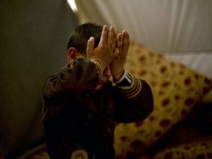 Akram Rasho Khalaf nasconde la faccia mentre parla degli abusi subiti dai terroristi (Foto AP/Maya Alleruzzo)