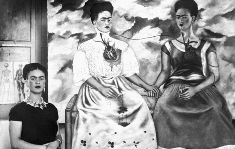 Frida Kahlo accanto ad uno dei suoi quadri più famosi