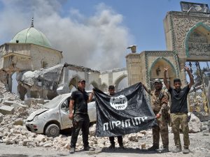 Membri esercito iracheno in posa con bandiera Isis dopo aver liberato Mosul