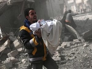Un neonato viene soccorso dopo un bombardamento nella Ghouta orientale (Gettyimages)