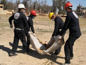 I membri del Comitato per la ricostruzione di Raqqa trasportano i resti ritrovati nello stadio della città. (Human Right Watch)