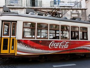 Uno dei simboli di Lisbona, il tram, con la pubblicità della Coca–Cola: ma per oltre quarant'anni in Portogallo la bevanda fu vietata.