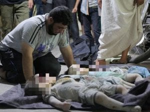 La disperazione di un padre davanti ai suoi tre figli uccisi nel bombardamento a Maaret al–Numan (Gettyimages)