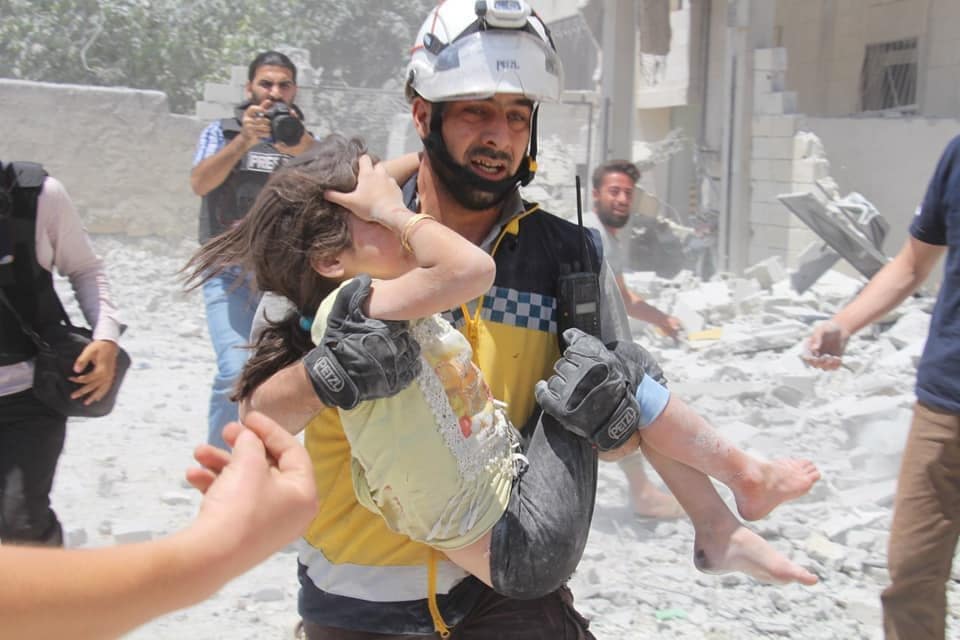 Un bimba soccorsa dopo un raid aereo nella Siria nord–occidentale (White Helmets)