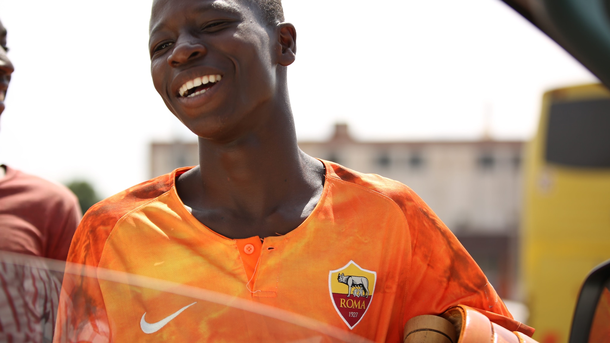 Ragazzo ivoriano venditore ambulante con maglia della A.S. Roma