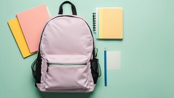 Zaino da scuola di colore rosa con intorno quaderni e matita