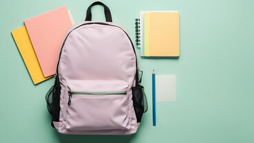 Zaino da scuola di colore rosa con intorno quaderni e matita