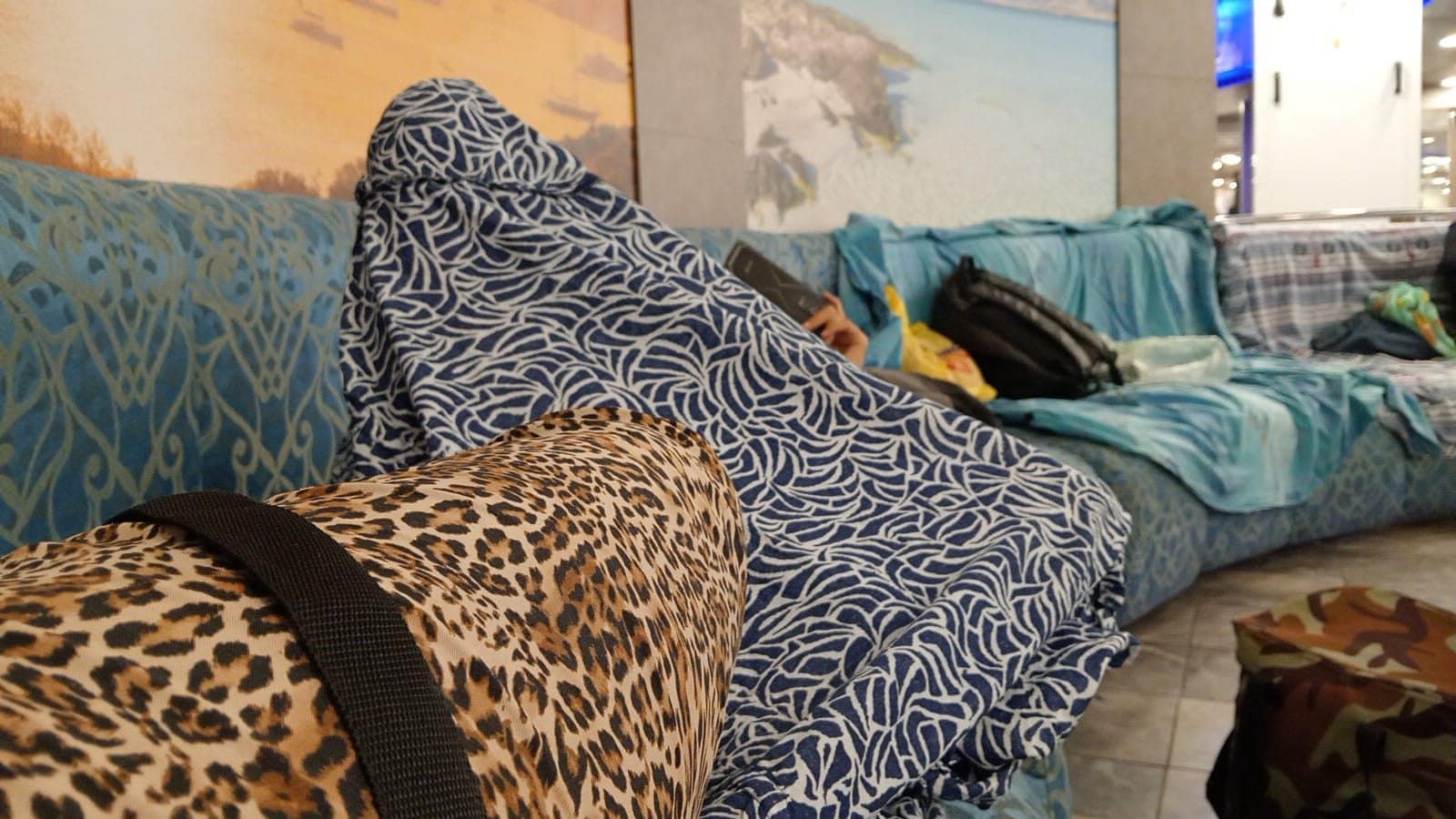 Le persone usano teli e asciugamani per accamparsi sui divanetti per la notte