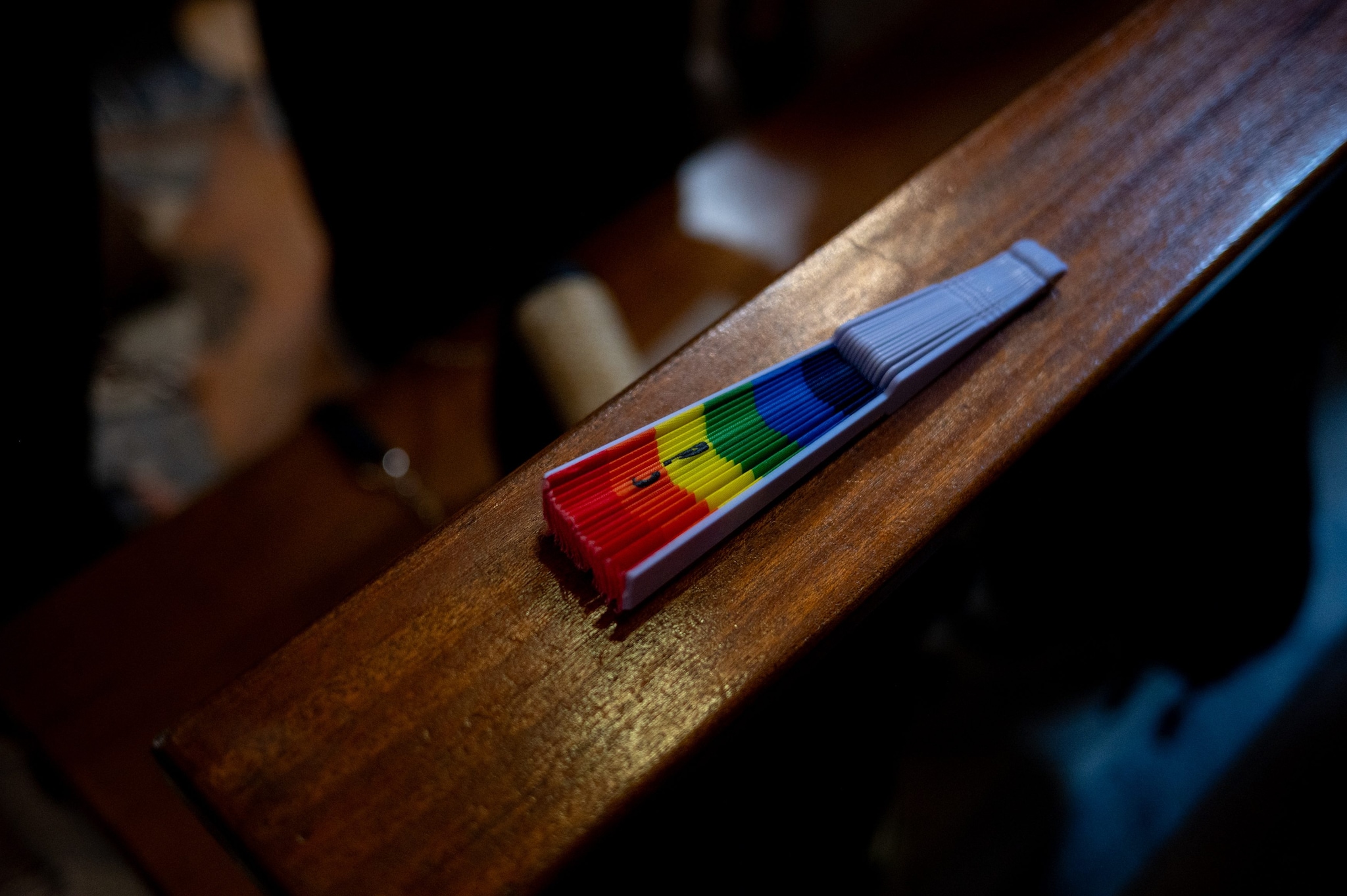 Un ventaglio arcobaleno appoggiato su uno dei banchi della Chiesa del Gesù.