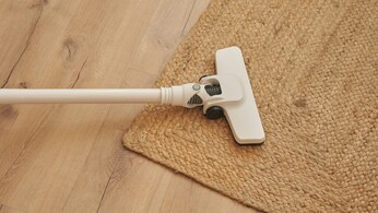 Aspirapolvere senza fili pulisce un pavimento con tappeto
