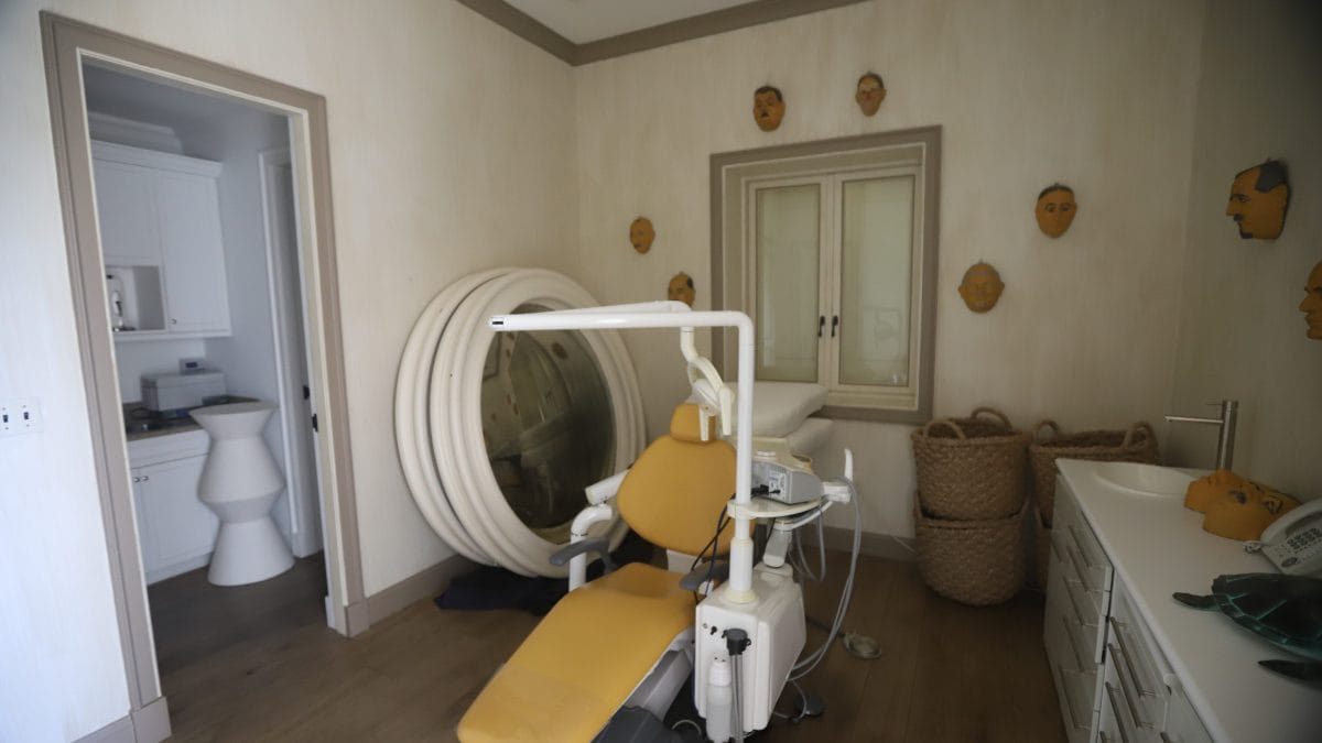 La poltrona da dentista con le maschere appese al muro.