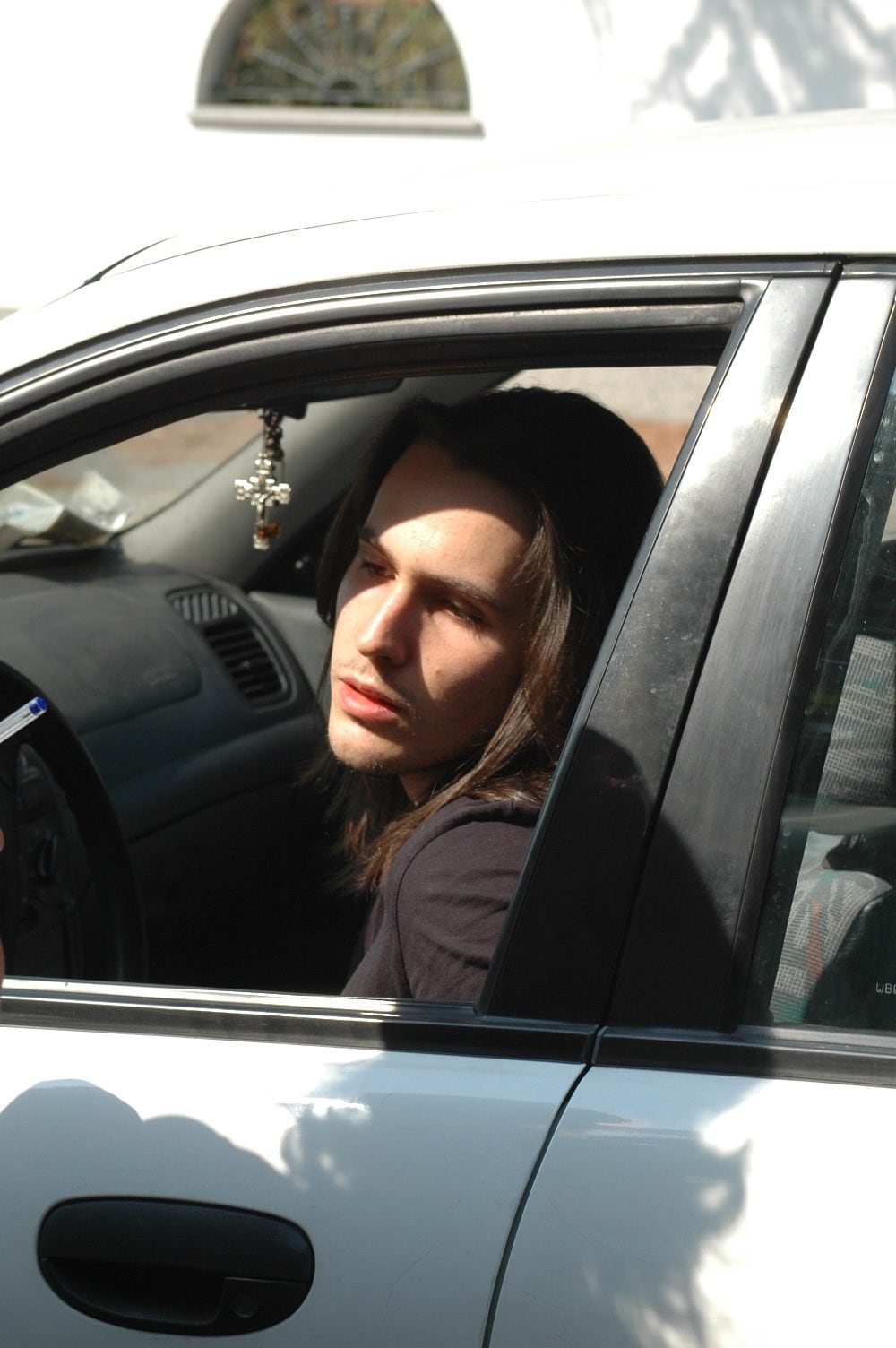 Andrea Sempio si sporge a guardare dalla macchina nera di famiglia