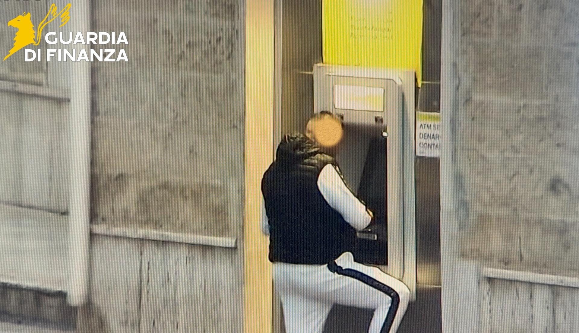 Uno dei presunti complici intento a prelevare i soldi dallo sportello ATM