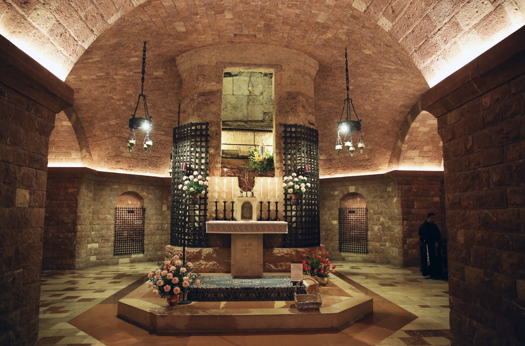 La tomba di san Francesco nella cripta. Dietro la grata metallica si trova il sarcofago in pietra checustodisce le spoglie mortali del Santo di Assisi