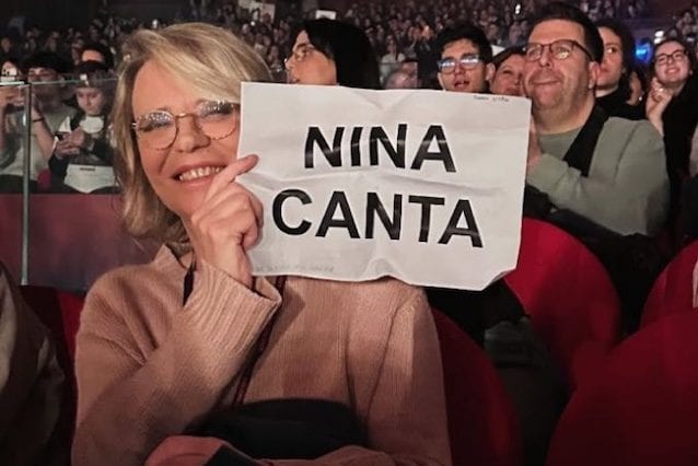 Maria De Filippi al concerto di Angelina Mango col cartello Nina canta