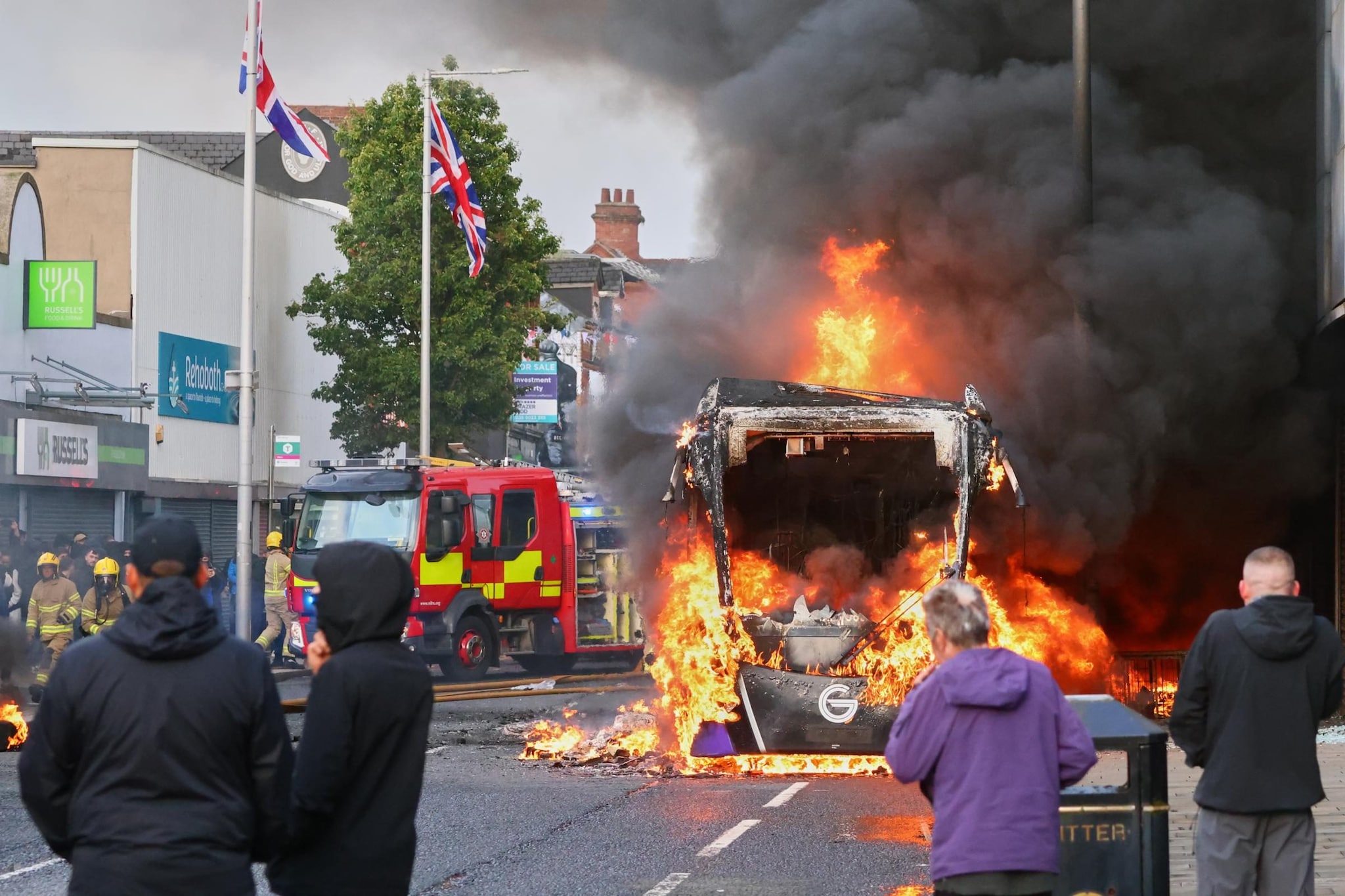 Cosa succede a Belfast: rifugiato tenta di uccidere un uomo, notte di scontri con case e auto in fiamme