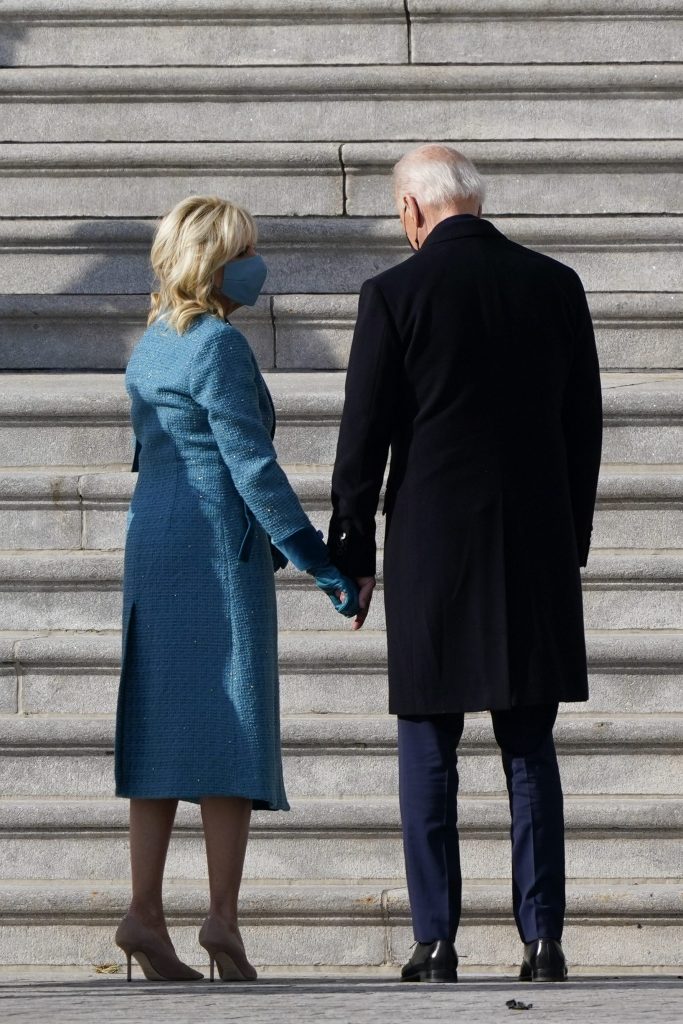 Jill Biden con l’abito azzurro dà la mano al marito Joe Biden