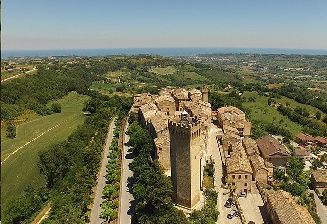 Veduta panoramica del borgo di Moresco con la torre eptagonale e la linea costiera all’orizzonte – Foto <a href="https://it.wikipedia.org/wiki/File:MorescoMare.JPG" target="_blank" rel="nofollow noopener">Wikipedia</a>