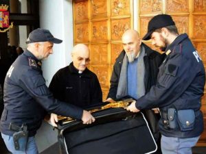 I poliziotti riconsegnano il crocefisso alla parrocchia di San Clemente – foto Polizia di Stato