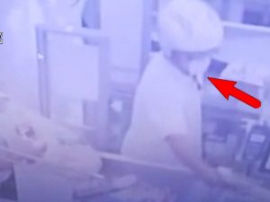 Uno dei rapinatori in azione in uno dei tanti esercizi commerciali di Ostia presi di mira.