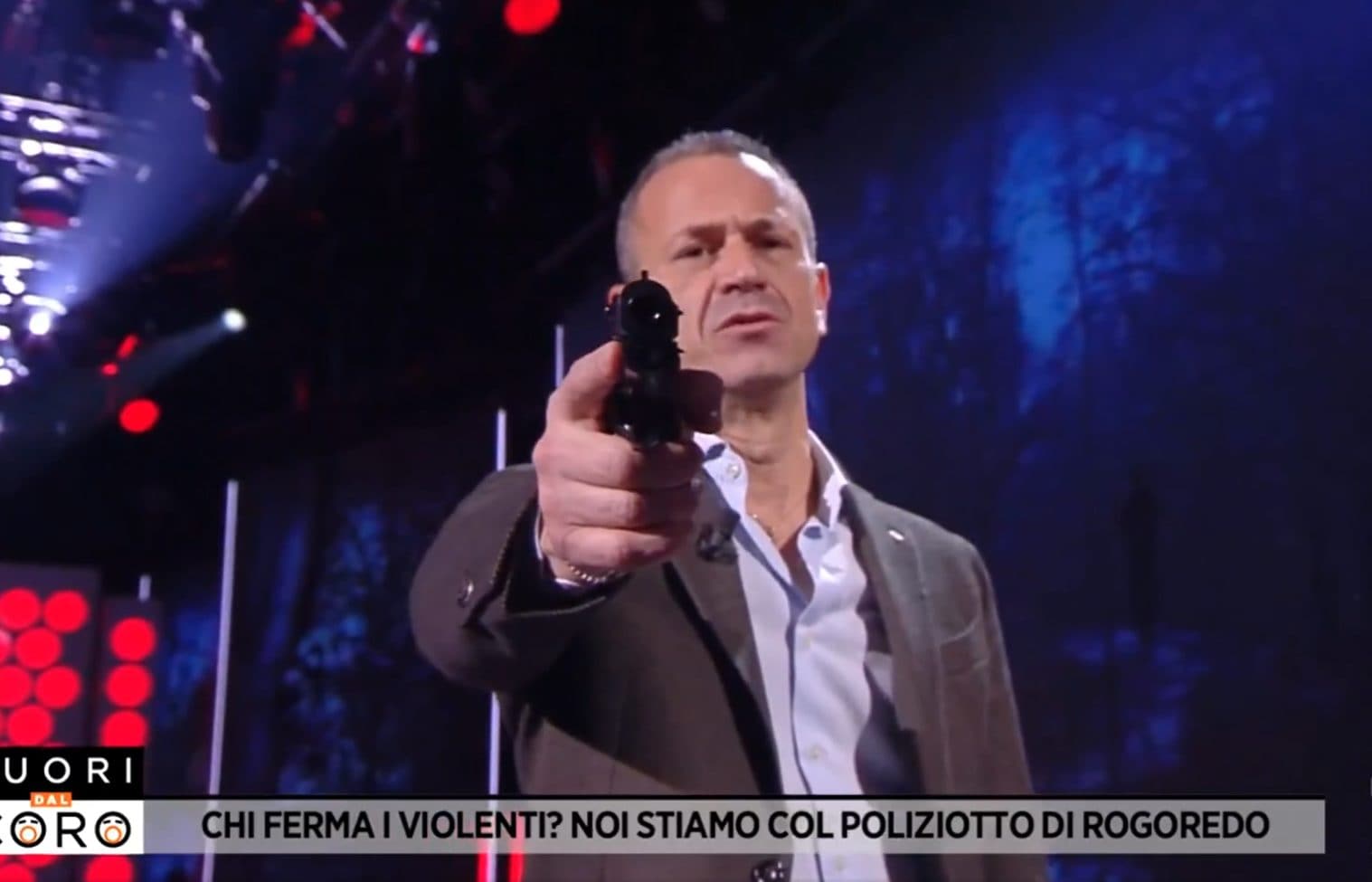 A Fuori dal Coro un poliziotto punta una pistola in camera verso gli spettatori: “Non ci farete arrendere”