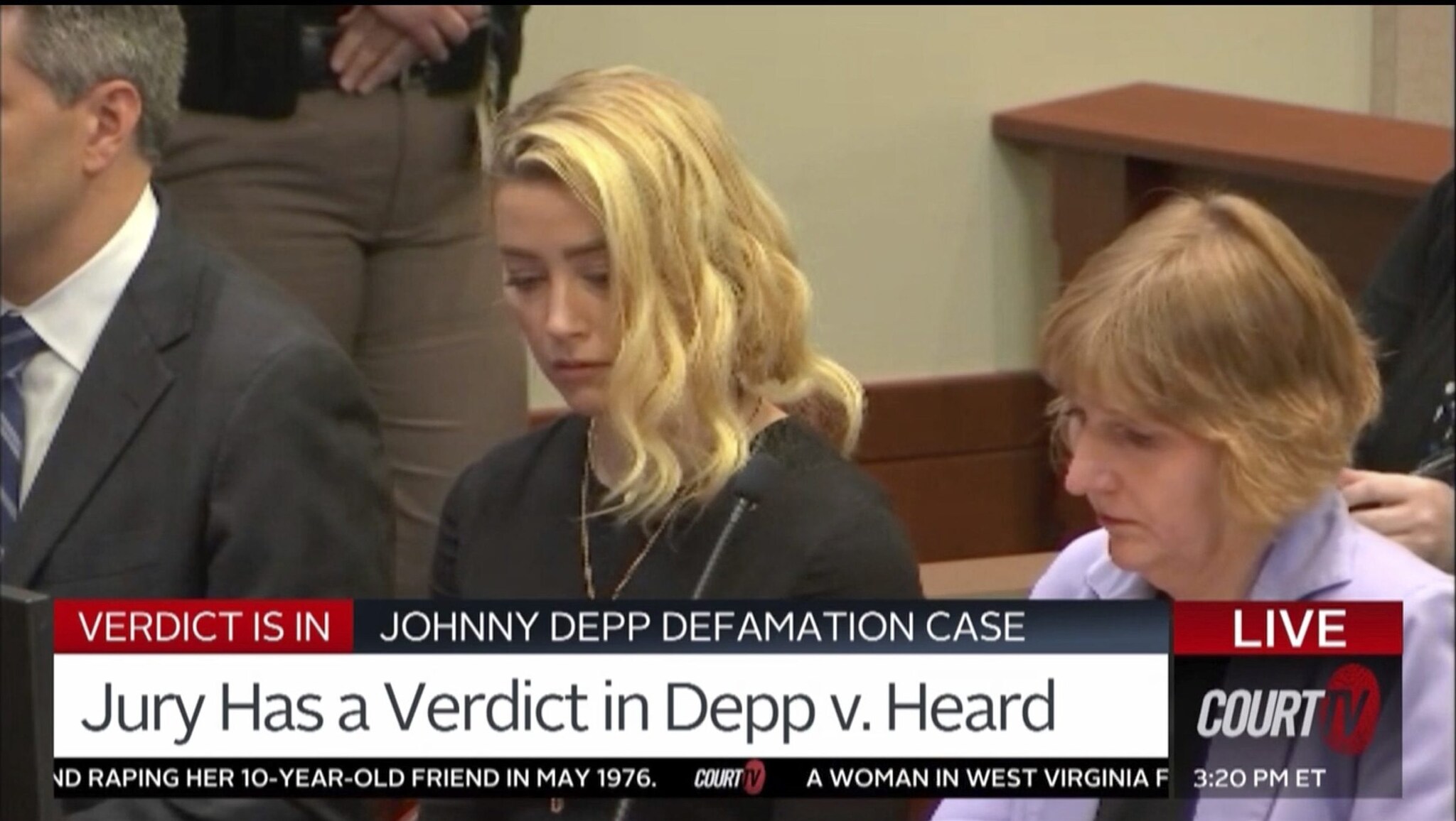 La reazione di Amber Heard al momento della lettura della sentenza in aula, accanto a lei c’è il suo avvocato, Elaine Bredehoft.