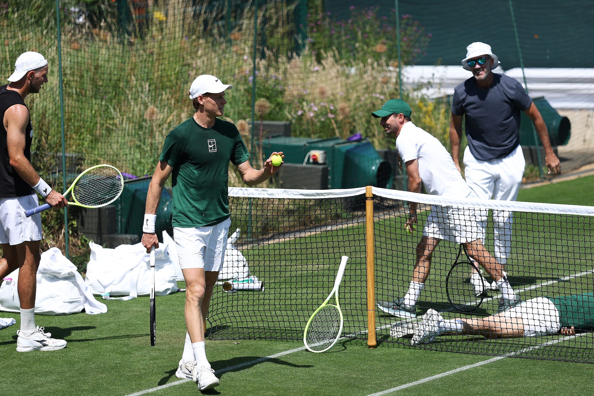Jannik Sinner in allenamento sotto il sole di Wimbledon assieme al suo team