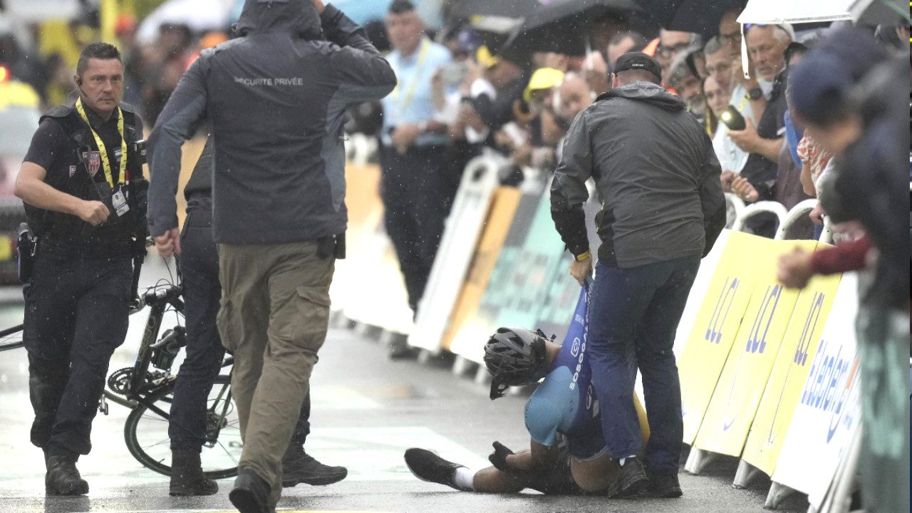 Tifoso in bici sul traguardo, la goliardata al Tour finisce malissimo: la polizia lo schianta a terra