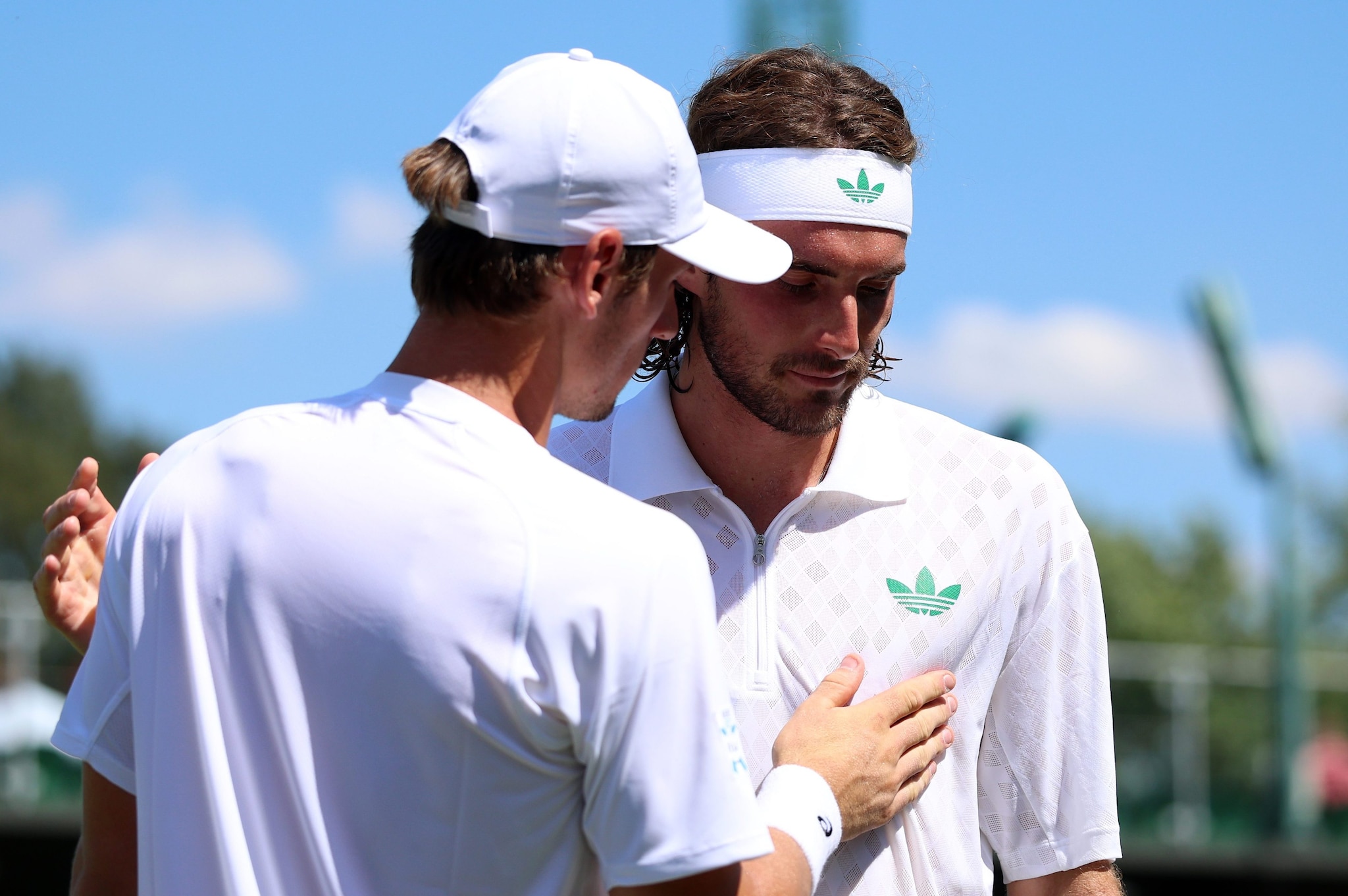 Tsitsipas saluta a rete Royer dopo essersi ritirato nel primo turno di Wimbledon