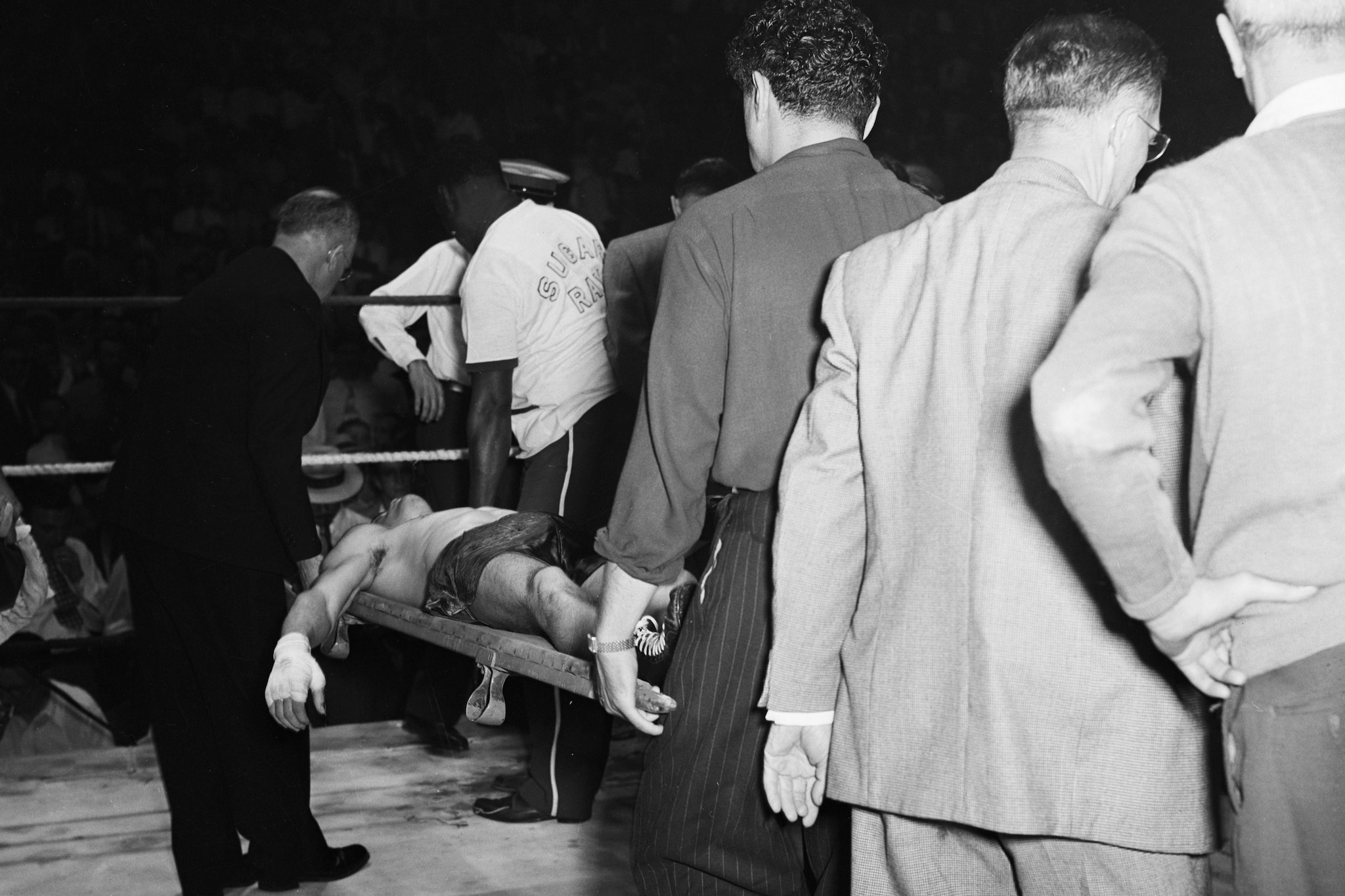 Jilly Doyle portato via in barella privo di sensi dopo essere stato messo KO da Sugar Ray Robinson