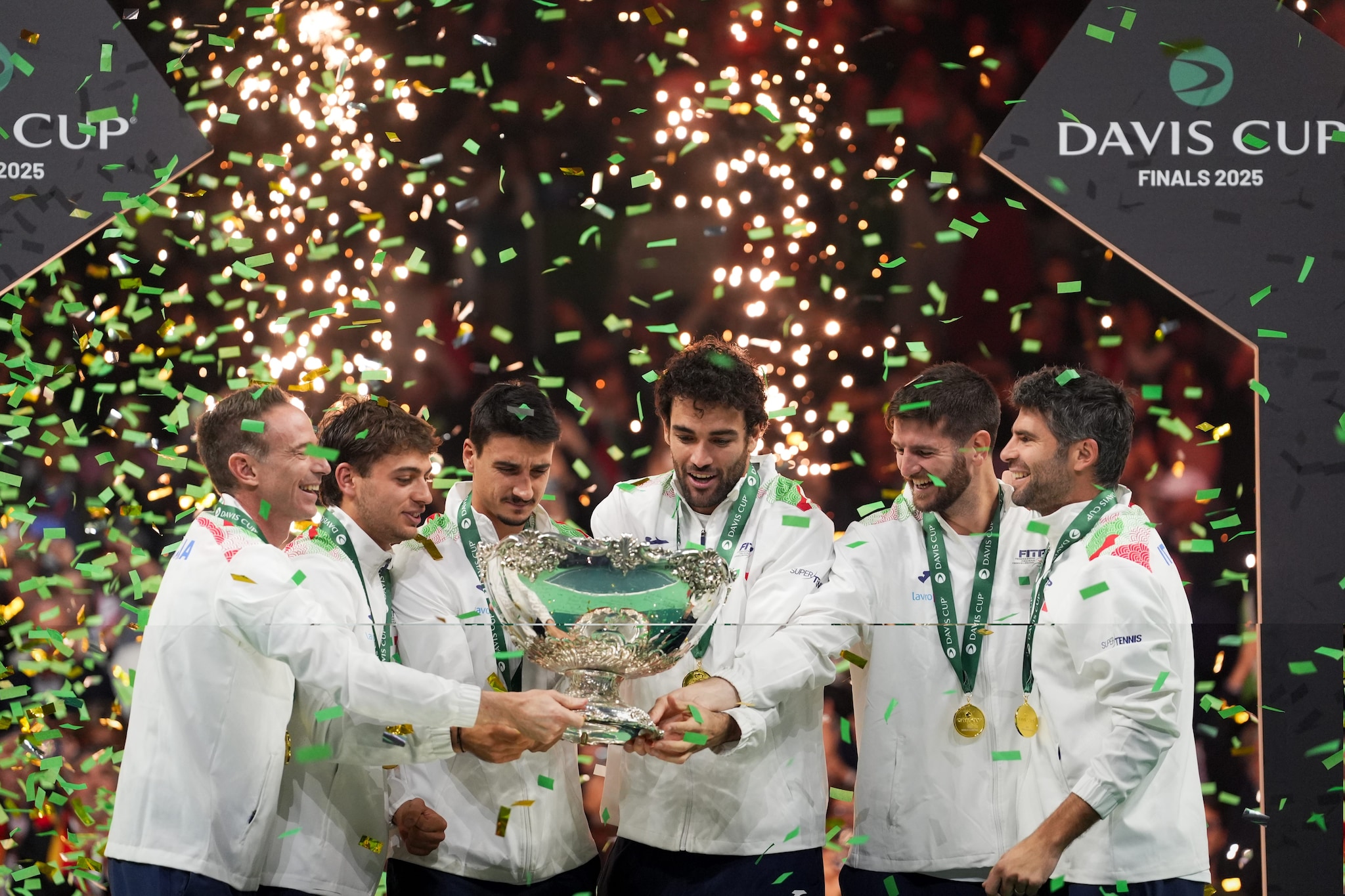 Capitan Volandri alza il trofeo insieme ai tennisti che hanno vinto la Coppa Davis a Bologna.