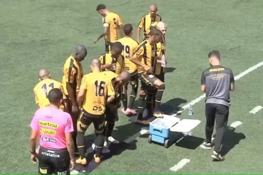 I calciatori si rinfrescano i piedi durante una delle interruzioni di Novorizontino e Juventude Samas