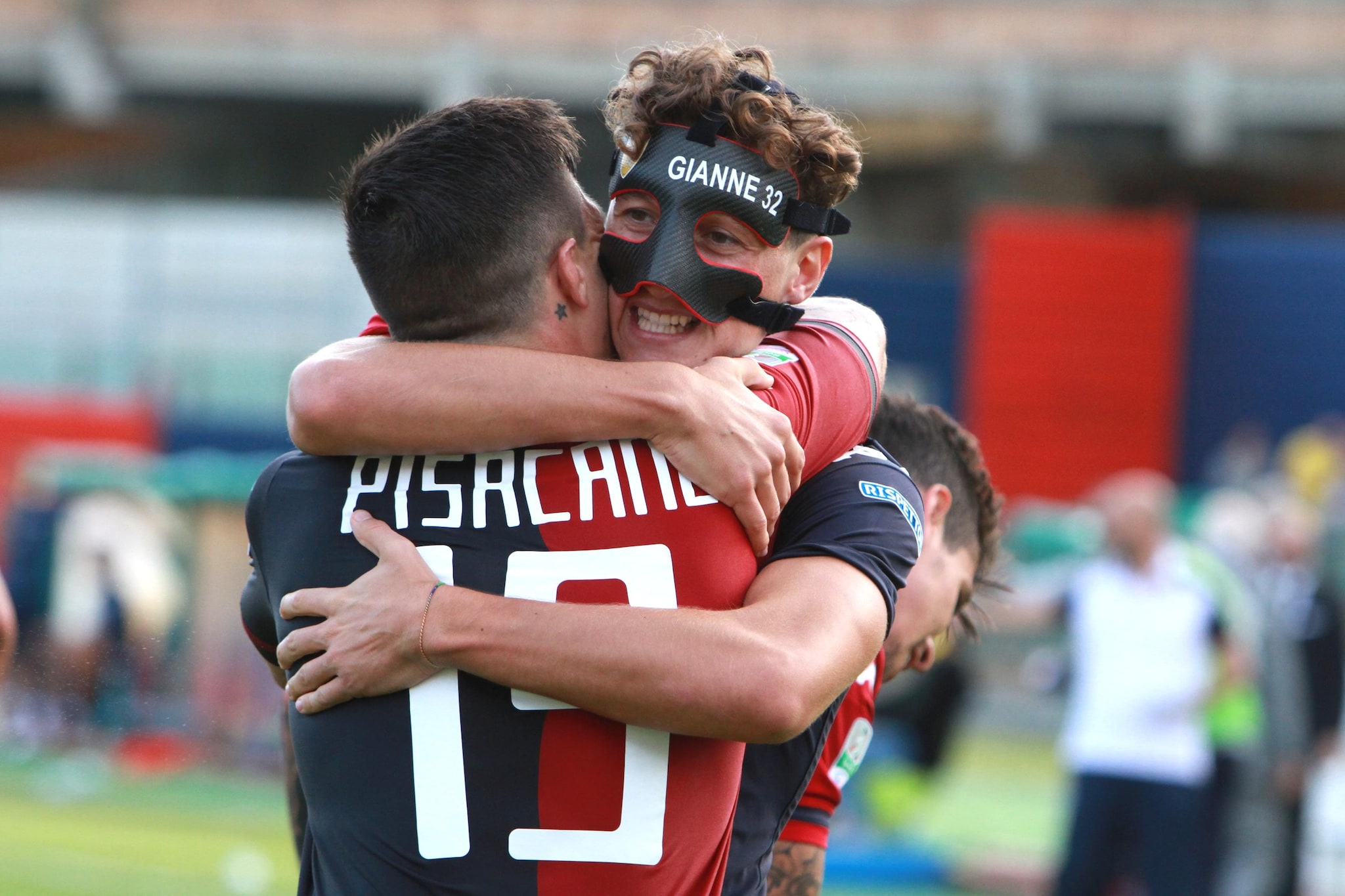 Giannetti, con la maschera, abbraccia Pisacane dopo un gol con il Cagliari.