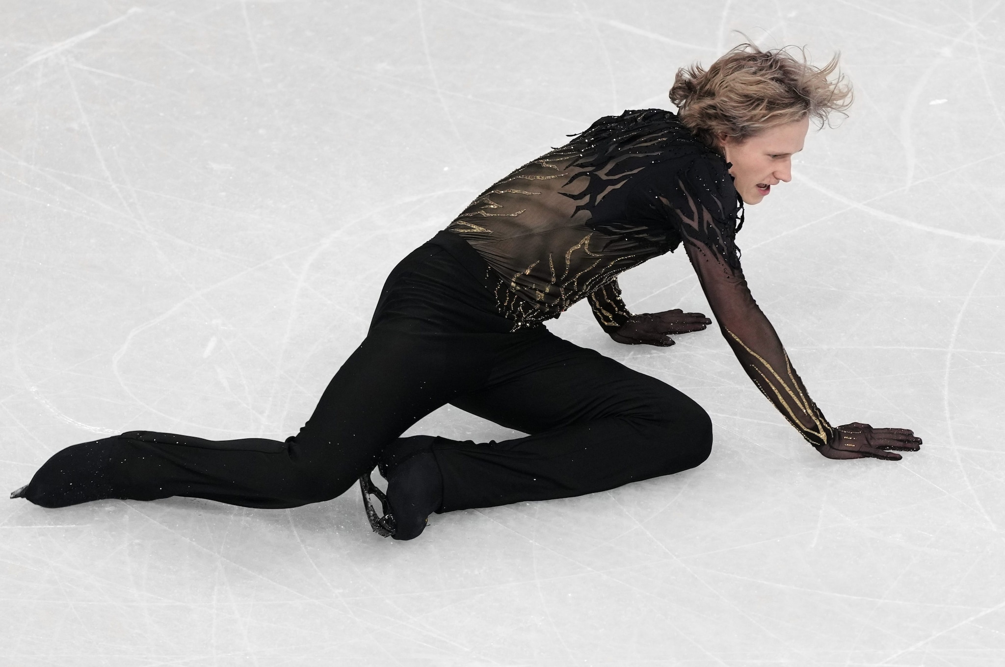 Ilia Malinin a terra sul ghiaccio di Milano dopo una delle sue due cadute