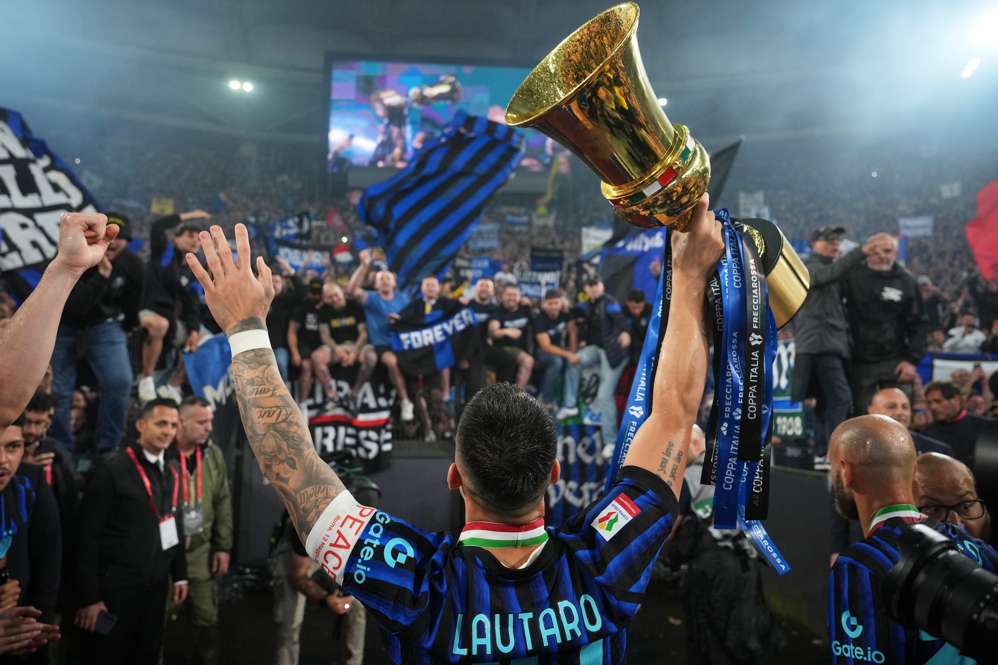 Lautaro Martinez con il trofeo della Coppa Italia sotto la curva dell’Inter.