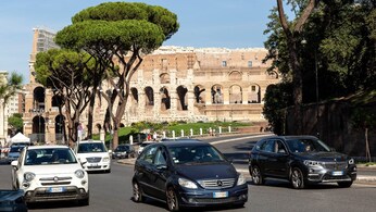 Auto in transito davanti al Colosseo a Roma.