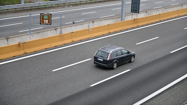 Un’auto nella corsia centrale dell’autostrada, con la corsia alla sua destra libera nel tratto inquadrato.