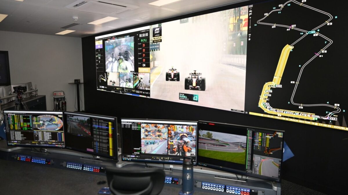 La sala di controllo FIA di Biggin Hill con i monitor che mostrano immagini delle monoposto, dati di gara e posizioni delle vetture sul circuito.