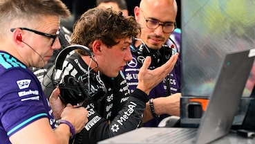 Kimi Antonelli parla con gli ingegneri Mercedes davanti ai computer nel box durante un weekend di Formula 1.