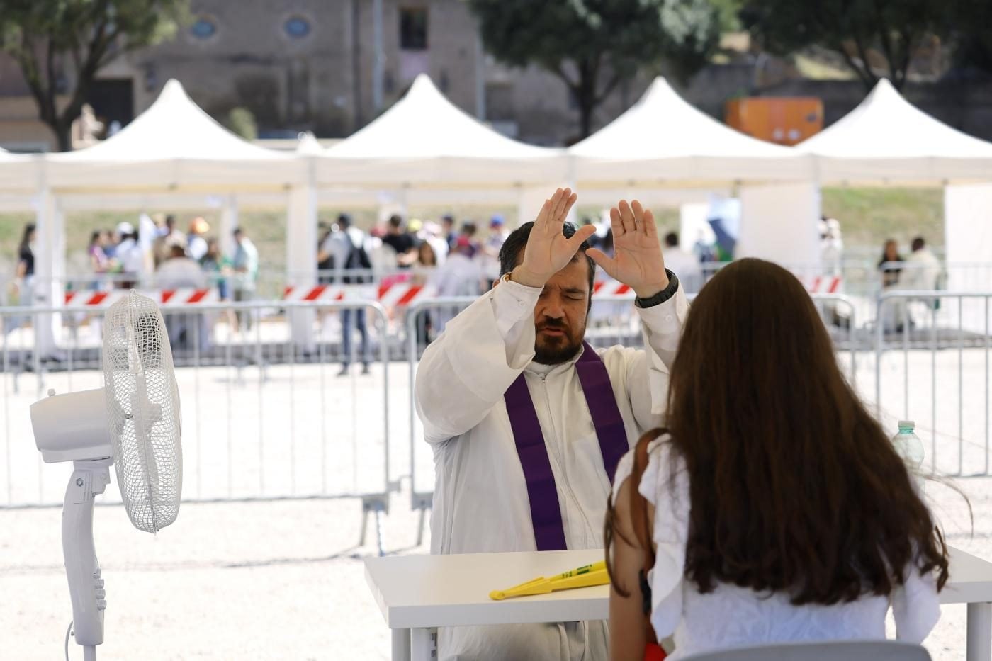 Un sacerdote che assolve una giovane al Circo Massimo (La Presse)