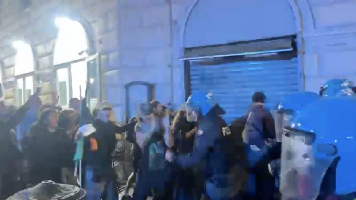 Un poliziotto spinge e manganella un manifestante