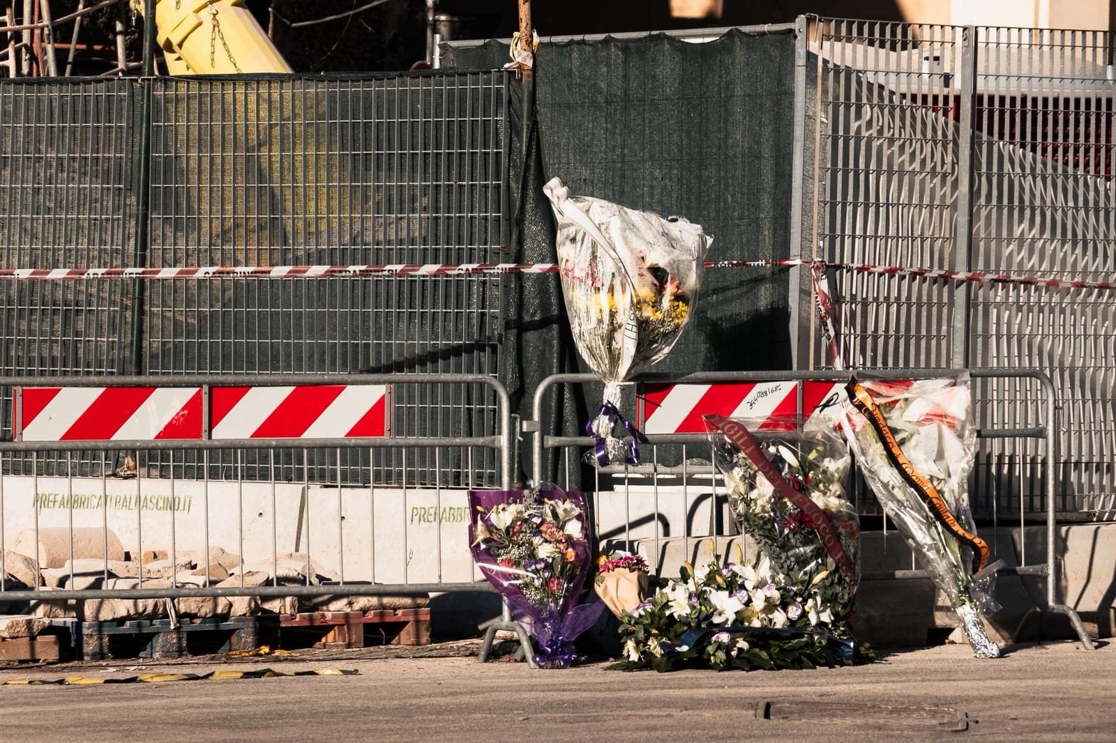 I mazzi di fiori sotto al cantiere.