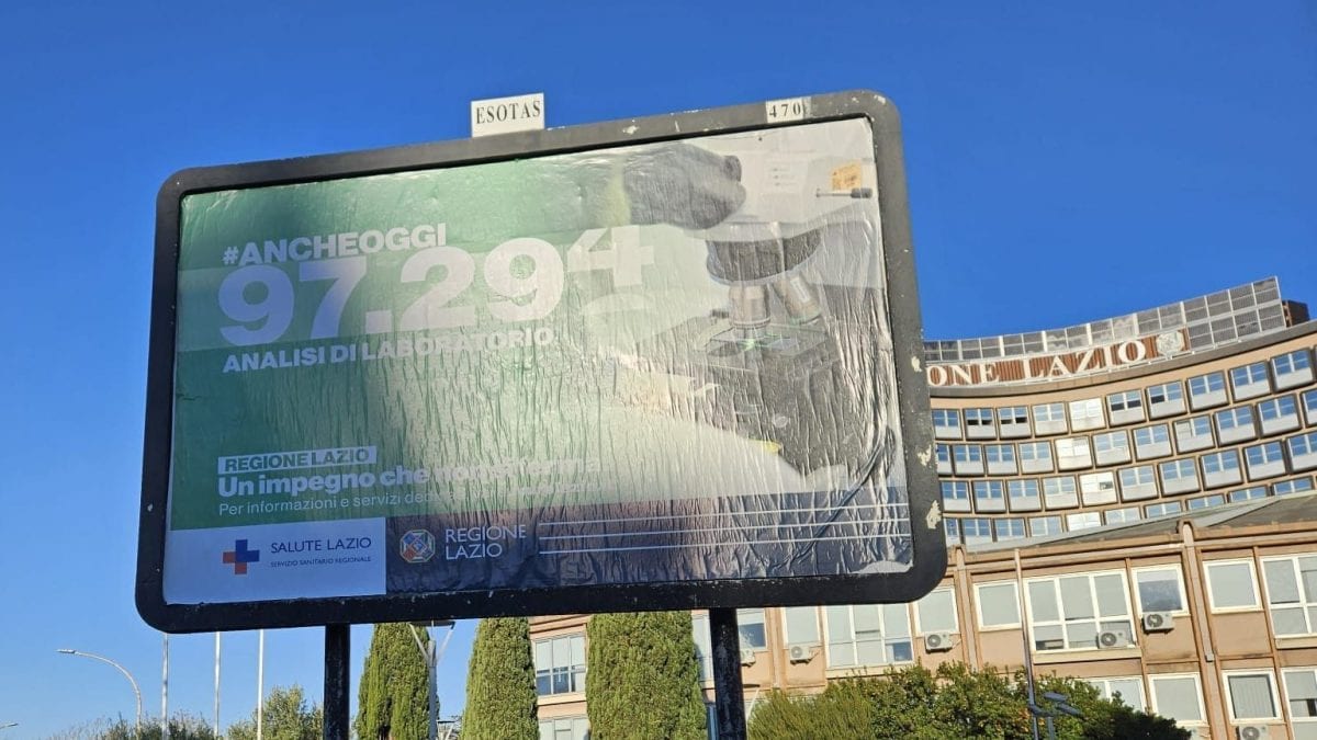 Uno dei manifesti della campagna "Anche oggi" davanti alla sede della Regione Lazio a Roma