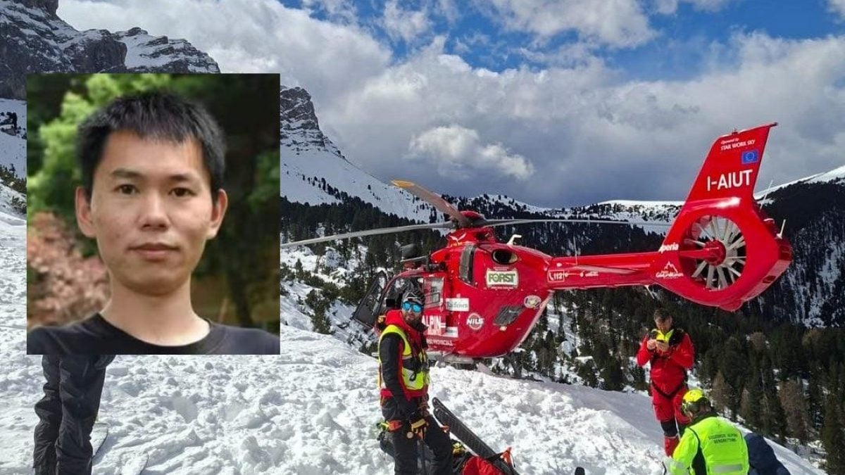 Haung Peng a sinistra. Sullo sfondo le operazioni dei soccorritori dell’Aiut Alpin Dolomites e gli agenti del Corpo Nazionale Soccorso Alpino e Speleologico.